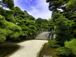 This image features the ornate wooden bridge that goes over the lake on the Kyoto Imperial Palace Grounds - image by Lisa Soots