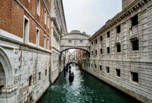 A gondola slowly moving under the Bridge of Sighs in Venice, Italy.