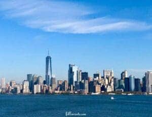 This image is of a waterfront view of the New York City Skyline with a blue sky above. Photo by Lisa Soots