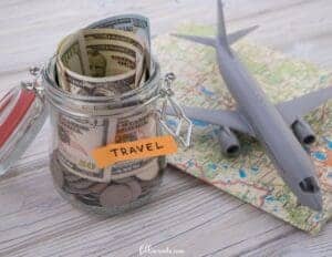 Creative Ways to Save Money for Travel - This image features a glass jar labeled travel with money inside, a model airplane and a map.