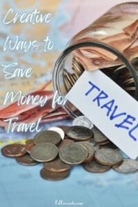 This image is a Pinterest Pin that features a glass jar laid on a table with coins falling out. The jar also has a paper labeled travel laying on the money.