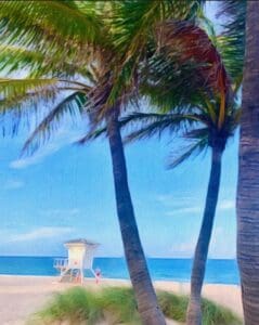 This image is of a lifeguard house on the beach by the ocean with three palm trees in the foreground of the image.