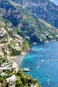 This image features a sweeping view of of the coast off the side of a cliff in Positana, Italy