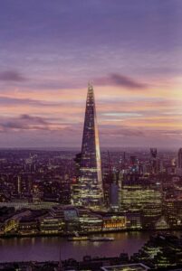 This image features the Shard in London overlooking the Thames River at sunset. 