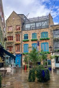 This image features brick buildings with colorful doors and shutters in the Covent Gardens neighborhood of London