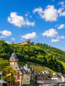 This image features a more close up view of Bernkastel- Kues looking from the water with the Castle High above