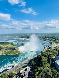 Stunning aerial view of Niagara Falls under a bright sky, showcasing its magnificent beauty.