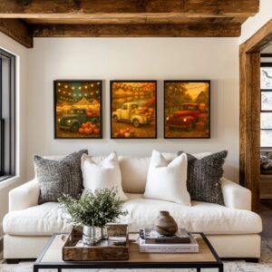 Set of three framed vintage fall truck printable wall art pieces displayed above a cream sofa, featuring pumpkins, apple orchards, rustic barns, glowing string lights, and warm autumn colors.