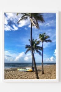 This image features a dreamy beach scene with blue sky and clouds, palm trees in the breeze and a raft on the beach below the palm trees. - Pretty Home Decor Ideas & Pretty Prints for Your Walls