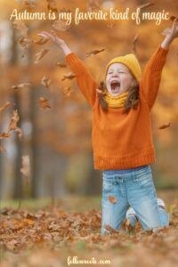 Cozy Autumn Quotes- This image features a little girl jumping up in the air and throwing autumn leaves. She is wearing an orange sweater and yellow beanie.