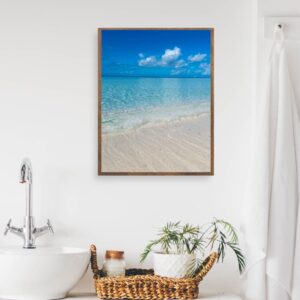 This image features a Caribbean Blue beach in a frame over a white sink in a spa-like bathroom.