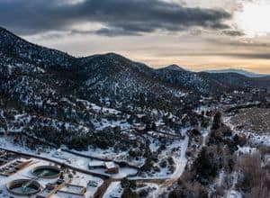 Breathtaking aerial view of snowy Santa Fe mountains during sunset, showcasing winter tranquility and scenic beauty.